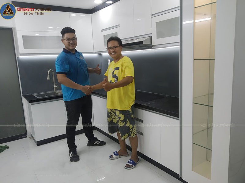 Nụ cười thỏa mãn của anh Đăng cùng nhân viên Xuyên Việt sau khi tủ bếp lắp đặt xong
